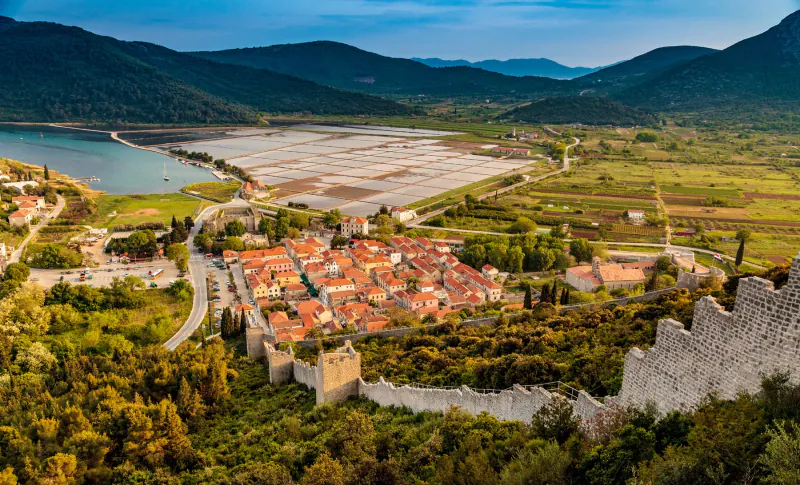 Aerial view of Ston’s fortress, red-roofed houses and walls climbing the hillside