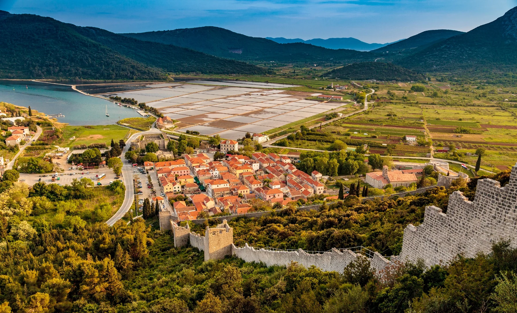 Aerial view of Ston’s fortress, red-roofed houses and walls climbing the hillside